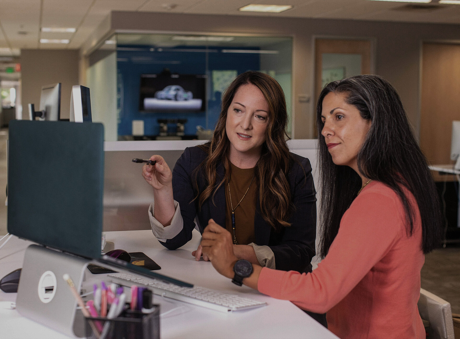 Zwei Personen unterhalten sich über Steuerplanung vor einem Laptop