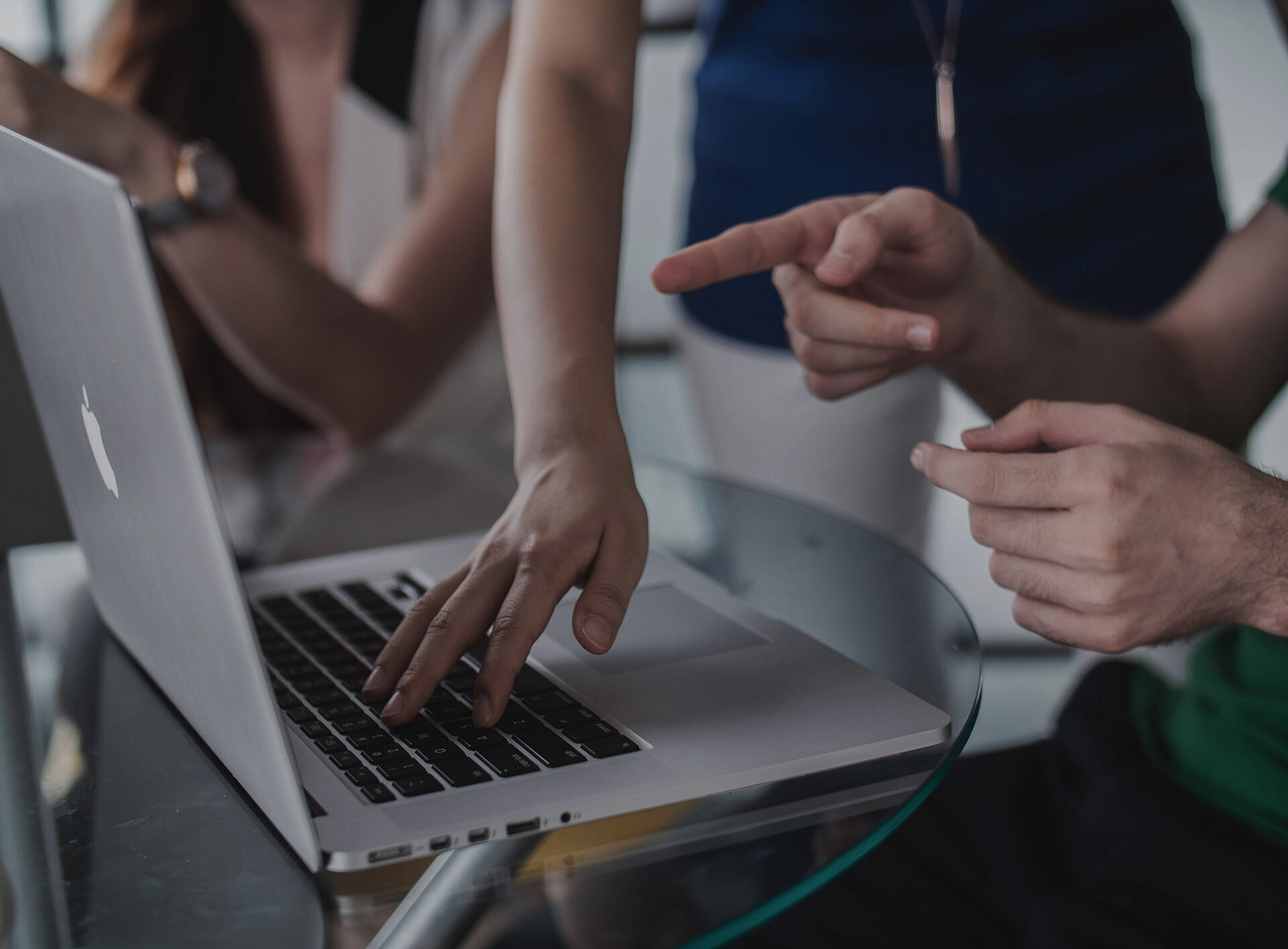 Mehrere Personen schauen auf einen Laptop