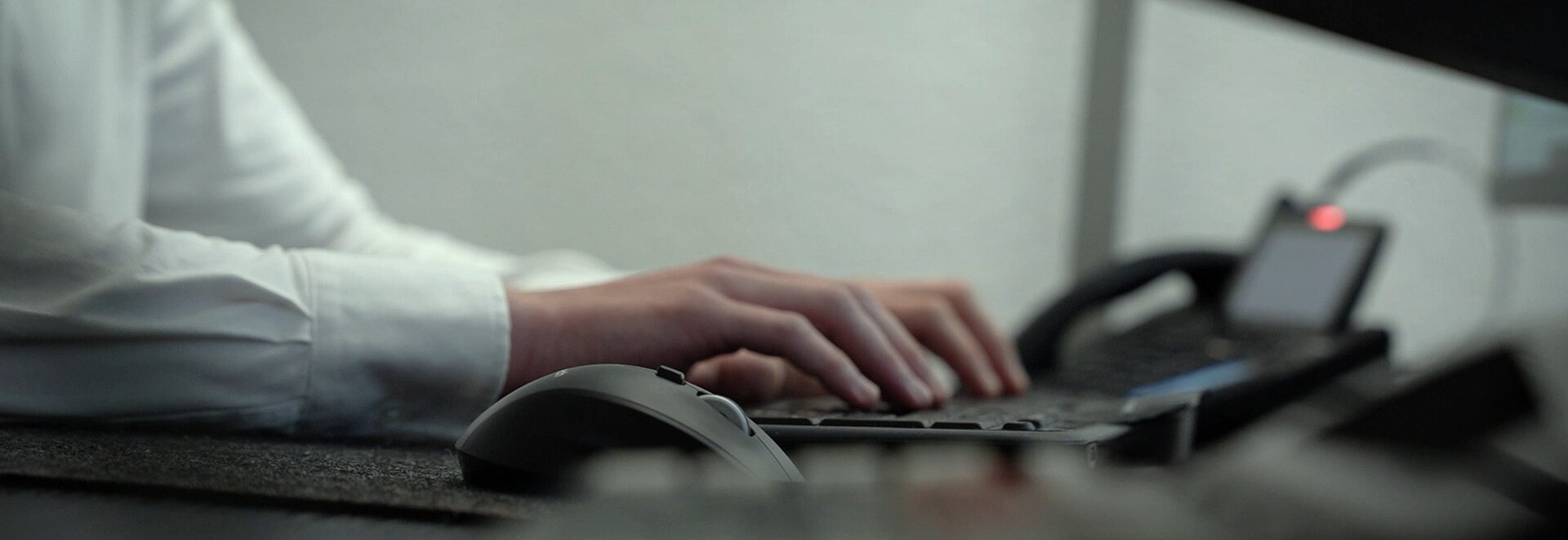 Nahaufnahme auf Hände die etwas auf einer Tastatur tippen