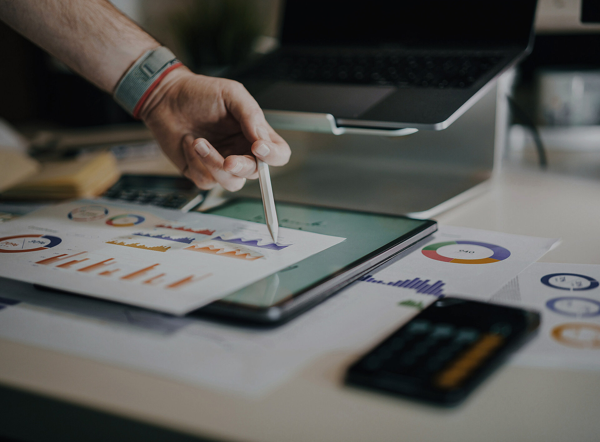 Ein Tablet und mehrere Diagramme auf Papier